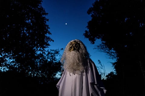 This picture taken on April 16, 2020 shows Urabil Alias, 38, wearing a ghost costume as he walks in a residential area to scare people from leaving their houses during the Movement Control Order. (Photo | AFP)