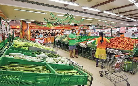 People shop for groceries at a supermarket. | Udayshankar S