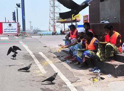 GVMC staff feeding crows in view of lockdown at beach road in Visakhapatnam on Friday. (Photo| EPS/G Satyanarayana)