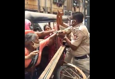 A scuffle broke out between a hawker and police personnel yesterday after she was not allowed to sell vegetables in a containment area in Mankhurd. (Photo | ANI)
