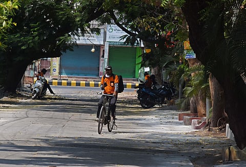 A home delivery boy searching the address for delivery in the red zone area. (Photo | EPS/Ravindra Babu)