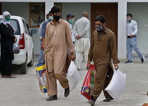 Daily wages workers carry sacks of wheat flour and other food supplies provided for free by a municipally, during a lockdown to try to contain the outbreak of the coronavirus, in Islamabad, Pakistan, Monday, April 6, 2020. (Photo | AP)
