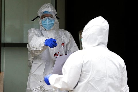 Medical staffers hold samples as they perform swabs for coronavirus in the Santa Cecilia nurse home in Civitavecchia, near Rome. (Photo | AP)