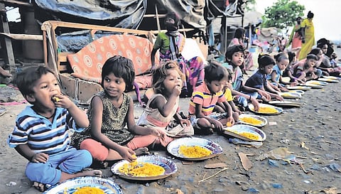 Children eat food provided by social workers at Nalasopara in Mumbai. (Photo | PTI)