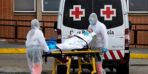 Emergency workers wearing full protective suits transport a patient to an ambulance at the Severo Ochoa Hospital in Leganes, Spain. (Photo | AP)
