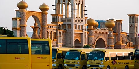 Dozens of school buses stand parked at the shopping theme park Global Village in Dubai. (Photo | AP)