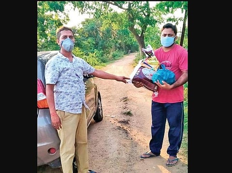 Ajay Das handing over relief supplies to a drummer.