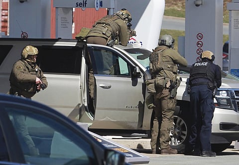 Royal Canadian Mounted Police officers surround a suspect at a gas station in Enfield, Nova Scotia, Sunday April 19, 2020. (Photo | AP)