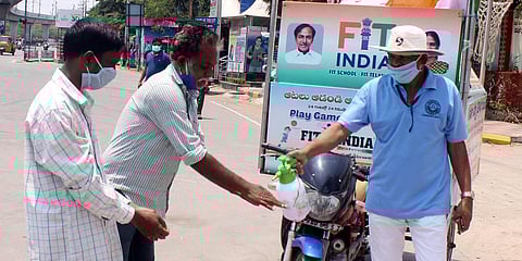 A man seen distributing hand sanitiser for the roadside people during the lockdown at Uppal in Hyderabad. (Photo| Sathya Keerthi, EPS)