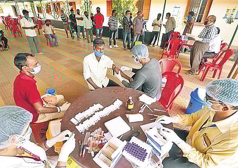 A health worker draws serum sample from a person for Covid-19 test at Unit-I Government Boy’s High School in Bhubaneswar on Sunday. (Photo| EPS/IRFANA)