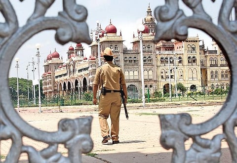 A policeman patrols the foreground of the Mysuru Palace on Thursday. The city has now been placed under a total lockdown. (Photo | Udayshankar S/EPS)