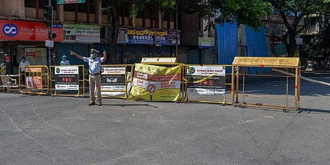 A lone traffic police officer mans a barricade amid the COVID-19 lockdown near Bengaluru's JC Road. (Photo| EPS)