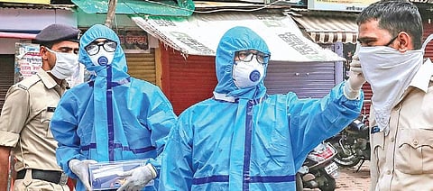 Health workers check body temperature of policemen deployed on lockdown duties in Bhopal on Sunday. (Photo | PTI)