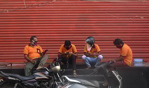 Food delivery boys waiting for parcel near a restaurant at Governorpet in Vijayawada on Monday. (Photo | EPS/Ravindr Babu)