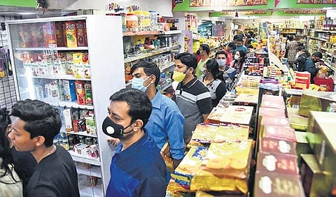People stand in queue to buy groceries.
