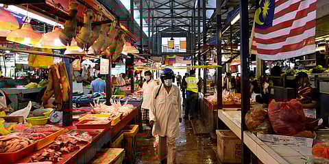 A man wearing a face mask to help curb the spread of the coronavirus shops at a wet market in downtown Kuala Lumpur. (Photo| AP)