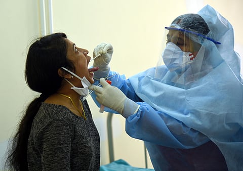 A Heath worker collects throat sampal at Governament hospetel as part of covid 19 in Bengaluru on Friday. (Photo | Nagaraja Gadekal, EPS)