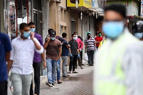 Foreign workers stand in line as they wait to be checked for the novel coronavirus at a testing centre in the Naif area of the Gulf Emirate of Dubai, on April 15, 2020. (PHOTOS | AFP)
