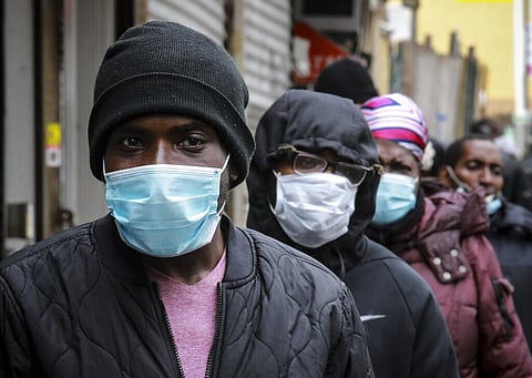 People wait for a distribution of masks and food from the Rev. Al Sharpton in the Harlem neighborhood of New York, after a new state mandate was issued requiring residents to wear face coverings in public due to the COVID-19 coronavirus, Saturday, April 1