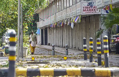 A woman walks past closed shops at Janpath market during a nationwide lockdown in the wake of coronavirus pandemic in New Delhi Tuesday April 14 2020. (Photo | PTI)