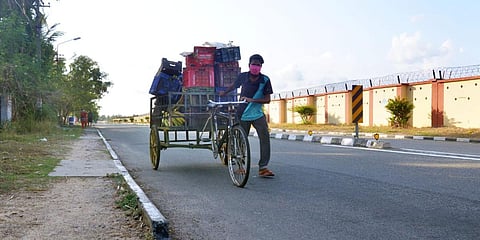A worker carrying essential items in a bicycle trolley for supplying to the Air Force camp near the domestic airport at Thiruvananthapuram. (Photo| Vincent Pulickal, EPS)