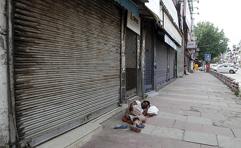 A homeless man takes a nap outside of a closed shop in old part of delhi during the nationwide lockdown. (Photo | Anil Shakya, EPS)