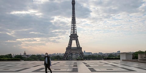 A man wears a mask to protect against the spread of the coronavirus as he walks along the Trocadero square close to the Eiffel Tower in Paris. (photo| AP)