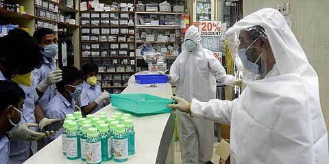 Pharmacy shop workers wear full protective gear suits during the nationwide lockdown to curb the spread of coronavirus, in Kolkata. (Photo| ANI)