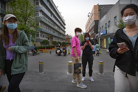 People wear face masks to protect against the spread of the new coronavirus as they walk through an outdoor shopping area in Beijing, Friday, April 24, 2020. (Photo | AP)