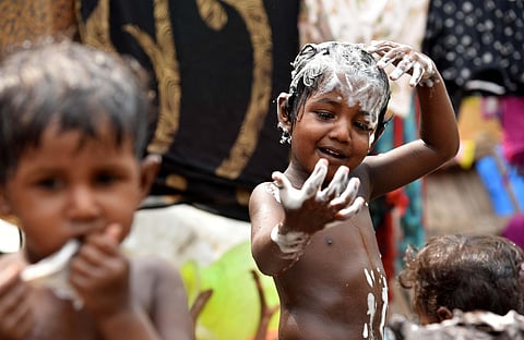 Kids taking a shower on the road side of Wall tax road, in chennai . (Photo | R Satish Babu, EPS)