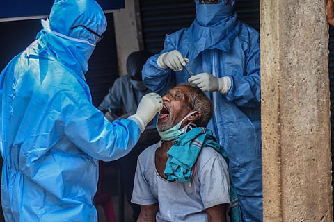 A health worker collecting swab sample at ID market in Bhubaneswar on Tuesday. (Photo | Biswanath Swain/EPS)
