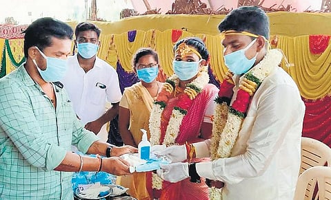 The bride and groom giving Thambulam of sanitisers and masks | Express