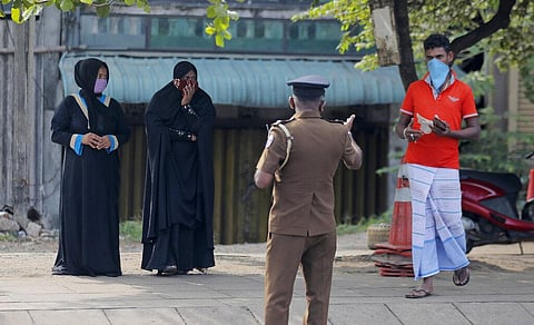 A Sri Lankan police officer detains curfew violators during a curfew imposed to curb the spreading of new coronavirus in Colombo, Sri Lanka, Wednesday, April 1, 2020. (Photo | AP)
