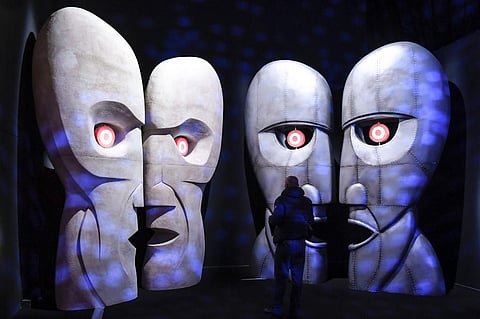 Visitors walk in front of a replica of the 'The Division Bell Metal Heads'during the 'The Pink Floyd Exhibition'. (Photo| AFP)