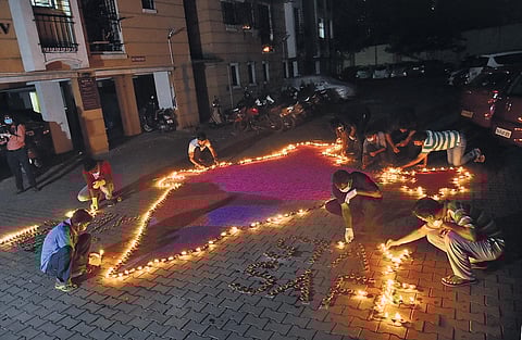 1. Residents of an apartment at Purasawalkam light diyas on Sunday | P Jawahar
