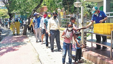 People form a queue while maintaining social distance to get food at an Indira Canteen in Bengaluru | VInod  Kumar T