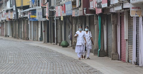 Two nurses walk down an empty SM Street to reach Kottapparambu Mother and Baby Hospital in Kozhikode during coronavirus lockdown. (Photo | Manu R Mavelil, EPS)