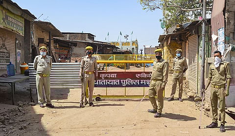 Police officials outside a residential area on Daresi Road after a resident residing in that area tested positive for coronavirus in Mathura Tuesday April 7 2020. (Photo | PTI)