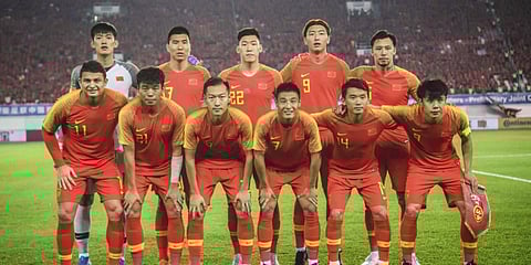 Chinese players pose for a team photo before the 2022 Football World Cup qualifier between China and Guam in Guangzhou, in China's southern Guangdong province. (File photo|AFP)