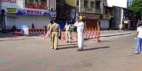 Police personnel stand guard near barricade during the ongoing lockdown to contain coronavirus pandemic, in Vadodara. (Photo| ANI)