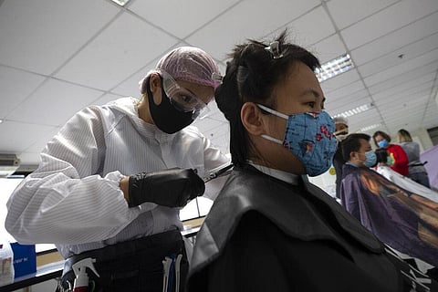 In this Tuesday, April 28, 2020, photo, Pornsupa Hattayong gives haircuts to a medical worker treating COVID-19 patients at Bangkok Metropolitan Administration General Hospital in Bangkok, Thailand. (Photo | AP)