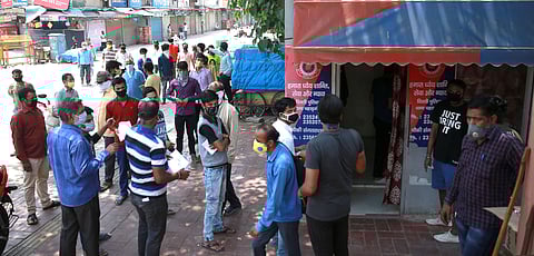 Delhi police personnel check the documents of migrant labourers who stuck in Delhi after the government order to send back the labourers to their hometown state in New Delhi on Thursday. (Photo | Shekhar Yadav/EPS)