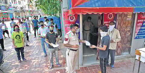Delhi Police personnel check documents of migrant labourers before their registration to return home  | shekhar yadav
