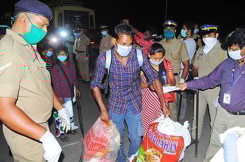 Migrant labourers who arrived to board the special train to Odisha receive the necessary goods provided by the state government at Aluva Railway Station on Friday. (Photo | EPS/ A Sanesh)