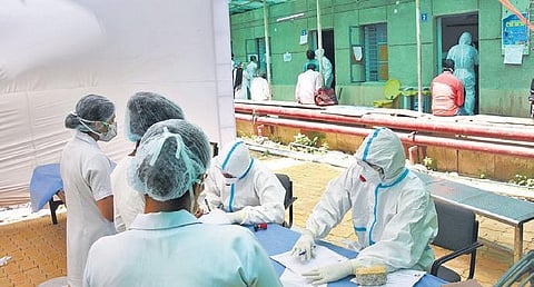 Doctors wearing protective suits sit at COVID-19 ward. (Photo | PTI)