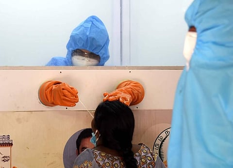 A health worker in a protective chamber collects samples for a swab test at Chennai's Saidapet during lockdown. (Photo | Martin Louis, EPS)