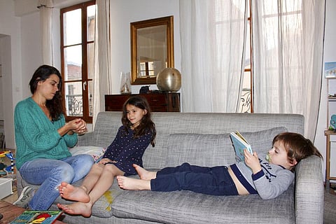 Mathilde Manaud plays on a sofa with her children Mila, 7, and Andre, 3, in Paris. (Photo | AP)