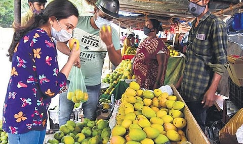 People buy mangoes from a stall on Jayamahal Road on Saturday | Vinod kumar T