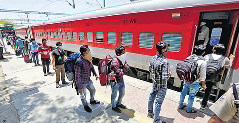Migrants wait for their turn to board a special train to Odisha at a railway station in Ahmedabad on Saturday. (Photo| PTI)