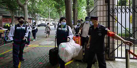 Students, wearing protective face masks to help curb the spread of the new coronavirus, arrive to a high school in Wuhan in central China's Hubei province. (File photo| AP)